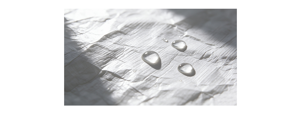 Water beading on Tyvek® fabric surface demonstrating hydrophobic water‑repellent property