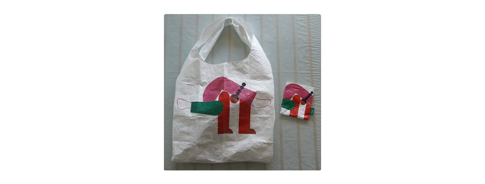 Printed reusable Tyvek® shopping tote bag alongside compact folded pouch version